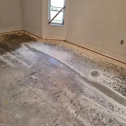 Bare concrete slab drying after wet carpet and pad were removed