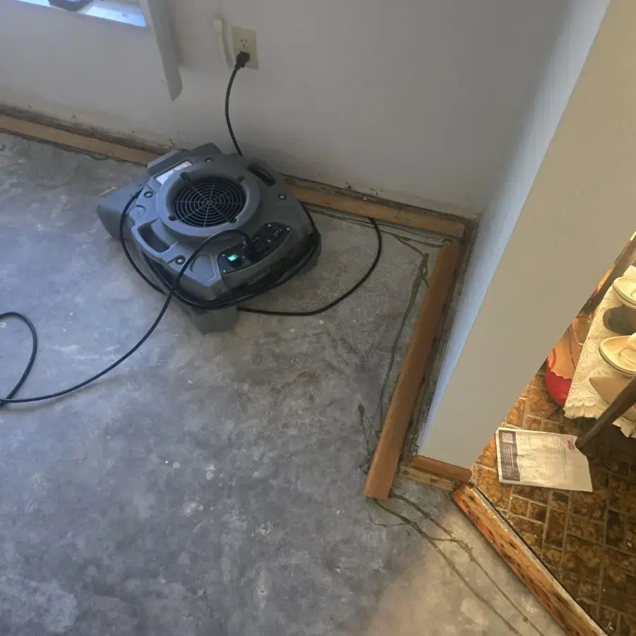 Air mover drying a slab edge where baseboards were pulled