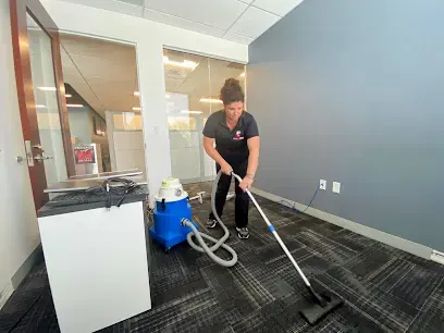Technician extracting water from carpet tile in an office