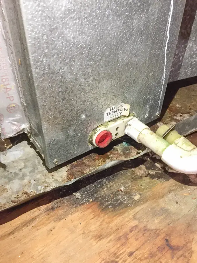 Air handler base with a condensate drain line and water-stained floor