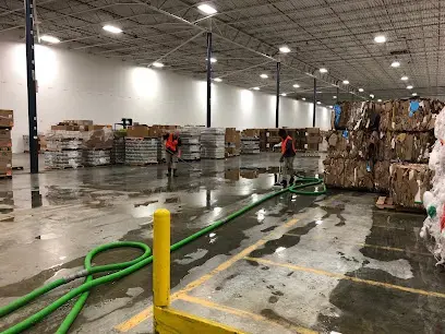 Extraction hoses and crews clearing water from a flooded warehouse floor